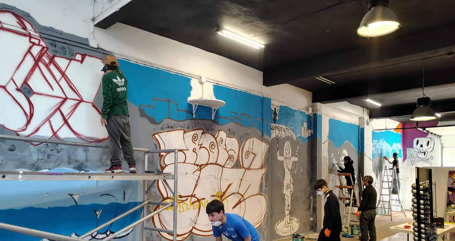 Los alumnos trabajan para la creación colectiva de un mural.